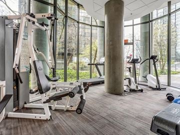 Vancouver condo for rent - A gym with a variety of equipment including a leg press machine.