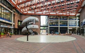 Vancouver condo for rent - A large atrium with a circular walkway and a large sculpture in the middle.