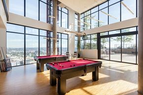 Vancouver condo for rent - A room with a pool table and a view of the city.