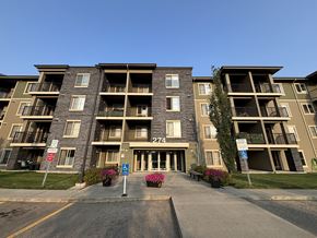 Edmonton condo for rent - Apartment building with a blue sign in front.