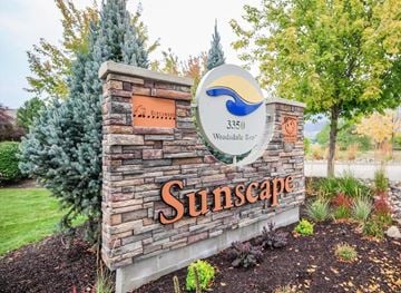 Lake Country townhouse for rent - A sign for Sunscape with a blue wave logo and a maple tree in the background.