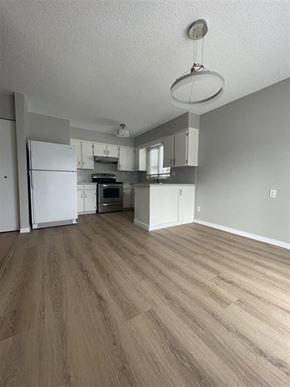 Coquitlam apartment for rent - an empty kitchen with white appliances and a wood floor