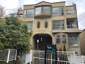 Vancouver apartment for rent - The Mary Court building is a multi-story residential building with a white fence in front.