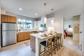 Lynnwood apartment for rent - an open kitchen and dining area with a white island and chairs