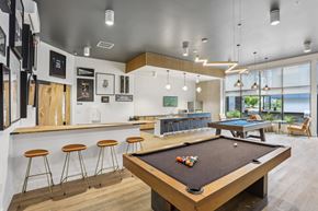 Lynnwood apartment for rent - A pool table is in the middle of a room with a bar and stools.