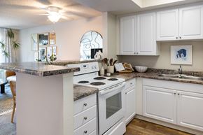 San Diego apartment for rent - A kitchen with white cabinets and a marble countertop.