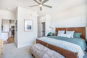 Greenwood Village apartment for rent - A bedroom with a large bed and a ceiling fan. at The Viridian Apartments, Colorado