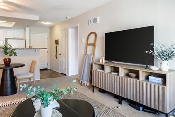 San Diego apartment for rent - A living room with a black table and a wooden entertainment center.