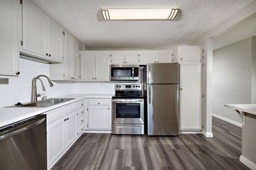 San Diego apartment for rent - A kitchen with white cabinets and stainless steel appliances.