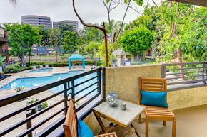 Irvine apartment for rent - a balcony with a pool and a table and chairs