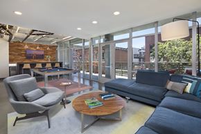 San Diego apartment for rent - A modern living room with a grey chair, a blue couch, and a wooden coffee table.