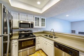 Irvine apartment for rent - a kitchen with stainless steel appliances and white cabinets