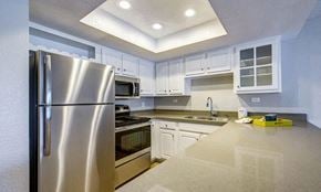Irvine apartment for rent - a kitchen with stainless steel appliances and white cabinets