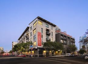 San Diego apartment for rent - A modern building with a red sign on the front.