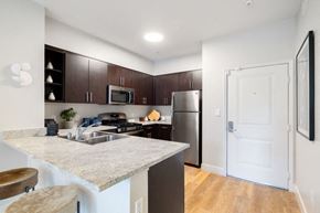 Woodland Hills apartment for rent - A kitchen with a white counter top and a white door.