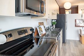 San Diego apartment for rent - A modern kitchen with a black stove top oven and a black refrigerator.