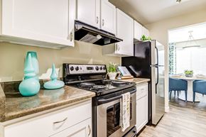 Bellevue apartment for rent - A kitchen with a black stove top oven and white cabinets.