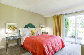 Bellevue apartment for rent - A bedroom with a red bedspread and a green headboard.