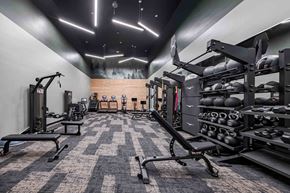 Tigard apartment for rent - A gym with a variety of equipment including weights and benches.