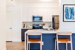 Cupertino apartment for rent - A kitchen with white cabinets and a blue backsplash.