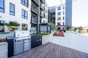 South San Francisco apartment for rent - an outdoor patio with a barbecue grill and a pool in front of an apartment building