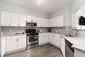 Johns Creek apartment for rent - a renovated kitchen with white cabinets and stainless steel appliances