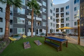 Milpitas apartment for rent - an outdoor amenities area with a ping pong table and an apartment building