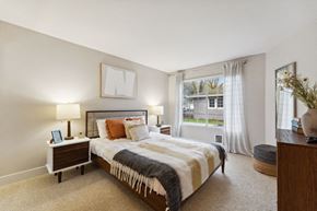 Beaverton apartment for rent - A bedroom with a large bed and a window with curtains.
