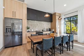 Hillsboro apartment for rent - a kitchen with a large wooden table and a stainless steel refrigerator