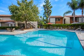 Thousand Oaks apartment for rent - A swimming pool surrounded by trees and houses.
