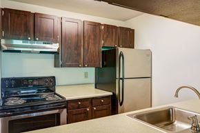 Tigard apartment for rent - A kitchen with a stove, sink, and refrigerator.