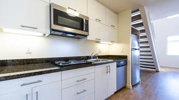 Glendale apartment for rent - A kitchen with white cabinets and a black countertop.