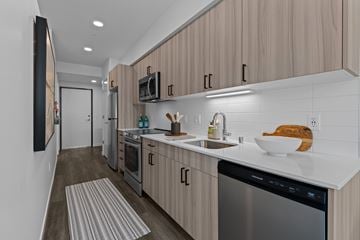 Shoreline apartment for rent - A modern kitchen with wooden cabinets and stainless steel appliances.