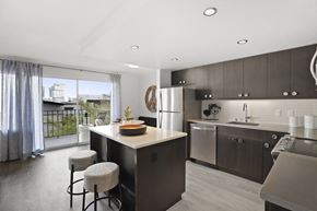 Seattle apartment for rent - a kitchen with a large island and a stainless steel refrigerator