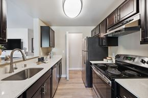 Sammamish apartment for rent - a kitchen with black appliances and white countertops and a stainless steel refrigerator
