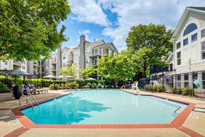 Fairfax apartment for rent - A swimming pool surrounded by trees and apartment buildings.