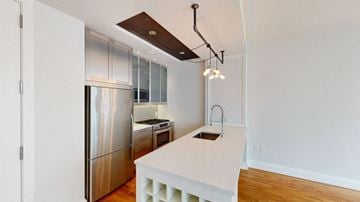 Brooklyn apartment for rent - A modern kitchen with a stainless steel refrigerator and a white countertop.