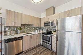 Seattle apartment for rent - an apartment kitchen with stainless steel appliances and wooden cabinets
