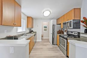 Pleasanton apartment for rent - A kitchen with wooden cabinets and stainless steel appliances.