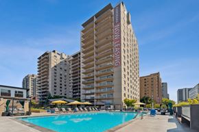 Seattle apartment for rent - a swimming pool in front of a tall apartment building