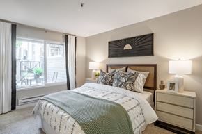 Sunnyvale apartment for rent - A bedroom with a large bed and a balcony with a table and chairs.