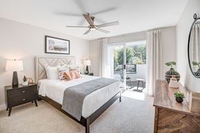 Irvine apartment for rent - A bedroom with a large bed and a ceiling fan.