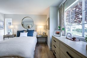 Oceanside apartment for rent - a bedroom with a bed and a dresser in front of a window