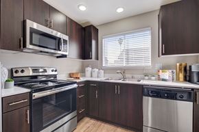 San Jose apartment for rent - a kitchen with dark wood cabinets and stainless steel appliances