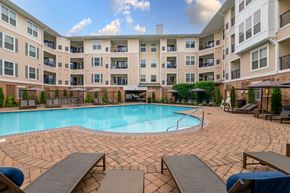 South Orange apartment for rent - a swimming pool with lounge chairs and umbrellas in front of an apartment building