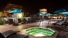 Glendale apartment for rent - A pool area with a hot tub and lounge chairs.