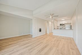 Oxnard apartment for rent - A spacious room with wooden flooring and a ceiling fan.