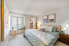 Tigard apartment for rent - A bedroom with a bed, nightstand, and a window with a view of a balcony.