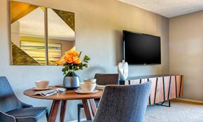 Belmont apartment for rent - a dining room with a table and chairs and a television