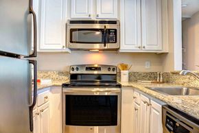 San Jose apartment for rent - a kitchen with stainless steel appliances and white cabinets